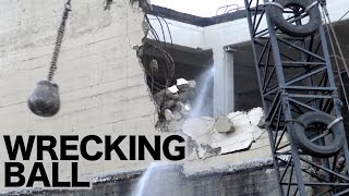 Wrecking ball in action demolishing a concrete building [upl. by Ynaffi]