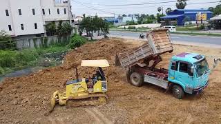 Dozer working with dirt pour soil delete water with dump trucks unloading [upl. by Ardaid973]