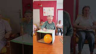 Players push long pins through a cardboard box attempting to pop the balloon [upl. by Forrest]