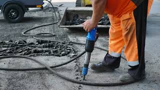 a road worker smashes the street asphalt with a ja 2023 01 04 19 20 35 utc [upl. by Brenan]